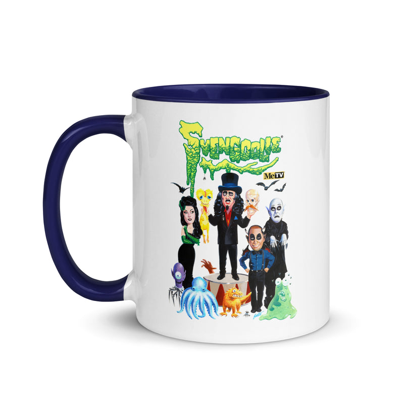 White mug with navy handle featuring Svengoolie and the Sven Squad alongside small monster characters with the text 'Svengoolie' in green dripping letters and a MeTV logo at the top.