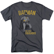 Charcoal gray t-shirt with gold text reading "BATMAN" above a photo of Batman in a costume, and "THE CAPED CRUSADER" below.