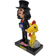 Right facing 3/4 view of Svengoolie bobblehead in black top hat, black suit, and blue shield with red emblem, beside yellow Kerwyn bobblehead on gray rock; base reads "Svengoolie" and "MeTV".