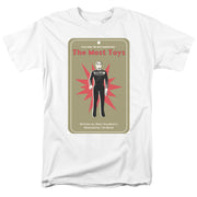White short-sleeved t-shirt featuring a tan trading-card graphic of a figure in a black uniform with the text 'The Most Toys' in red at the top