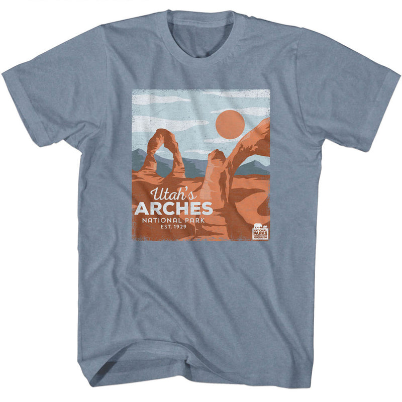 Blue-gray t-shirt with a retro illustration of orange sandstone arches, a large orange sun, and text 'Utah's ARCHES National Park EST. 1929'