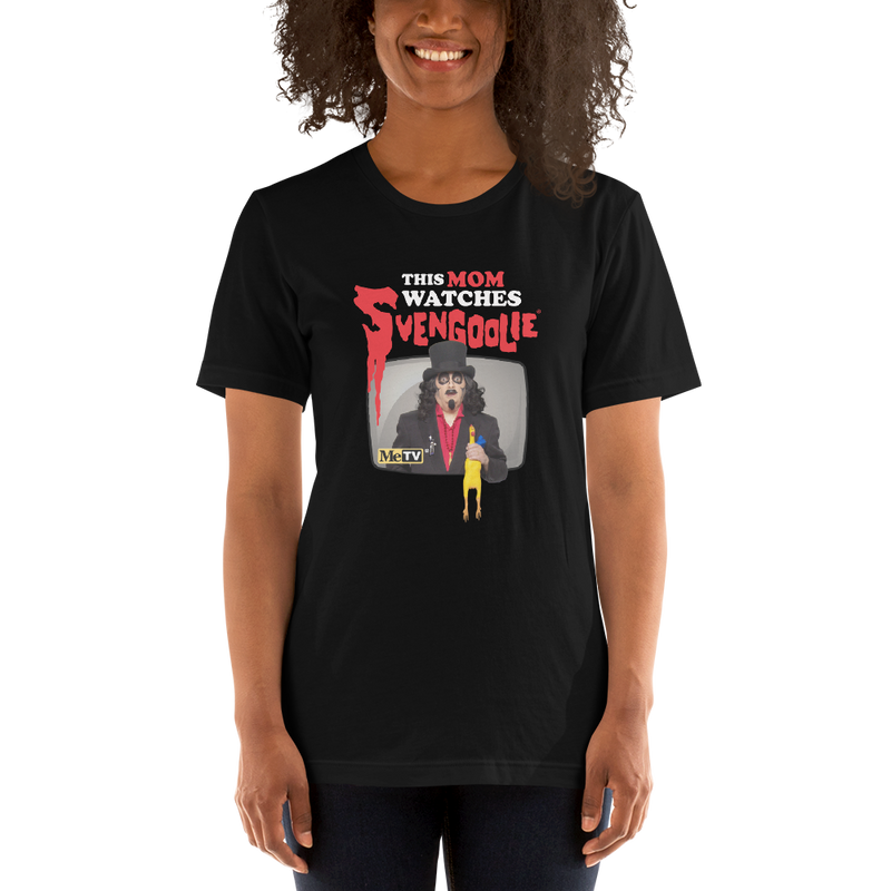 Model wearing Black t-shirt featuring Svengoolie holding a rubber chicken with the text 'This Mom Watches Svengoolie' in black and red above it.