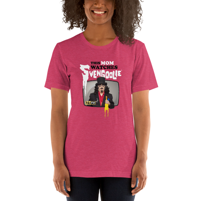Model wearing pink t-shirt featuring Svengoolie holding a rubber chicken with the text 'This Mom Watches Svengoolie' in black and white above it.