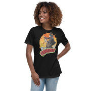 Black women's t-shirt with Svengoolie in top hat and black suit, at the top of a skyscraper, holding a skull, surrounded by rubber chickens, with 'SVENGOOLIE' in red letters over an orange sunset city.